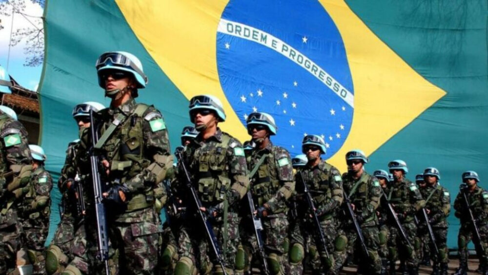 foto de soldados do Exército.Ao fundo há uma enorme bandeira brasileira.
